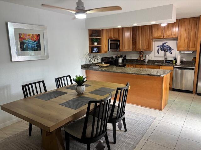 A dining area with a wooden table and chairs sits adjacent to a kitchen island — 1420 Ocean Way # 29a, Jupiter FL 33477, JUPITER, FL