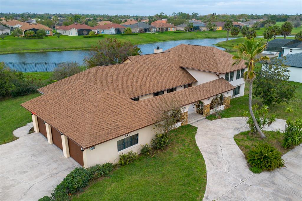 An aerial view of a suburban house with a brown shingled roof and a driveway — 513 BAR DRIVE, POINCIANA, FL