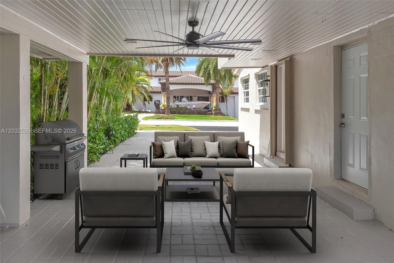 This covered outdoor patio features a seating area, a grill, and a ceiling fan — 424 W 13th St, Hialeah FL 33010, HIALEAH, FL