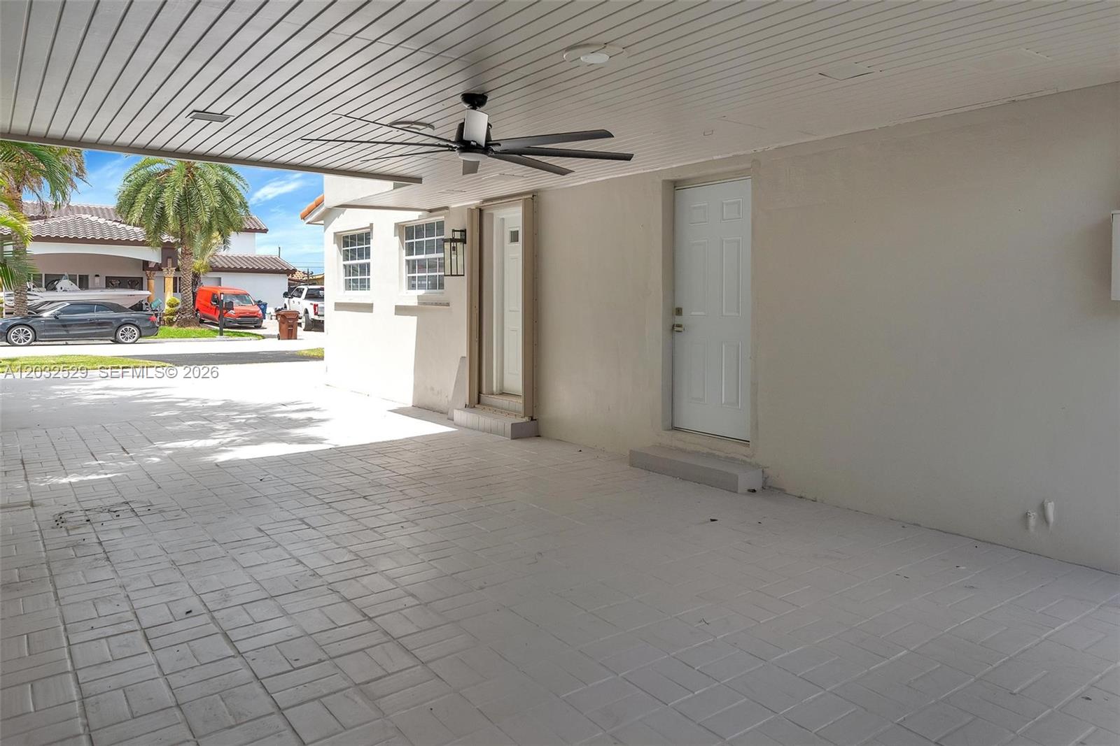 A covered patio features a ceiling fan, tiled flooring, and two white exterior doors — 424 W 13th St, Hialeah FL 33010, HIALEAH, FL