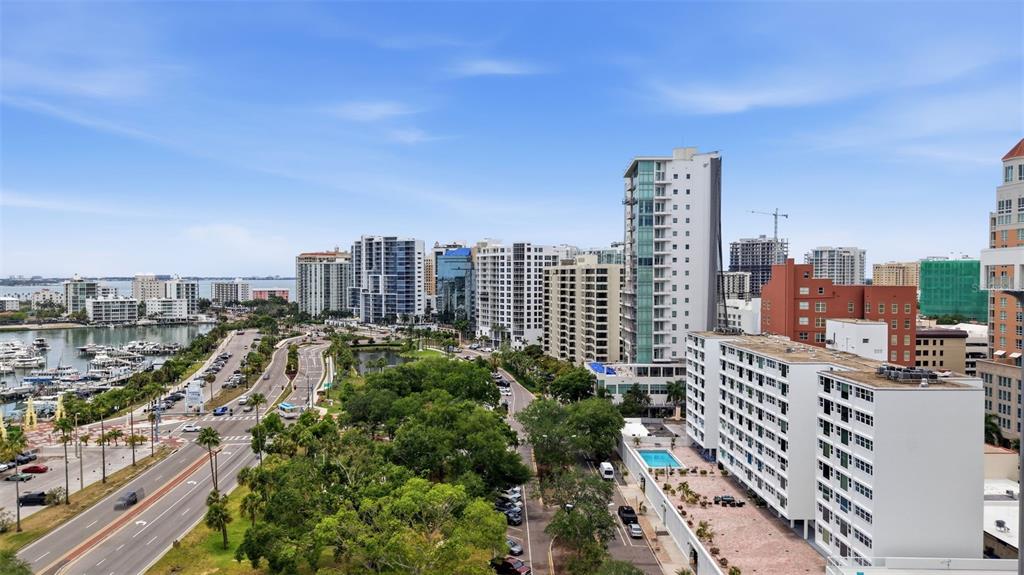 An elevated view of a coastal city skyline featuring high-rise buildings, a marina, and roads — 33 S GULFSTREAM AVENUE UNIT 404, SARASOTA, FL
