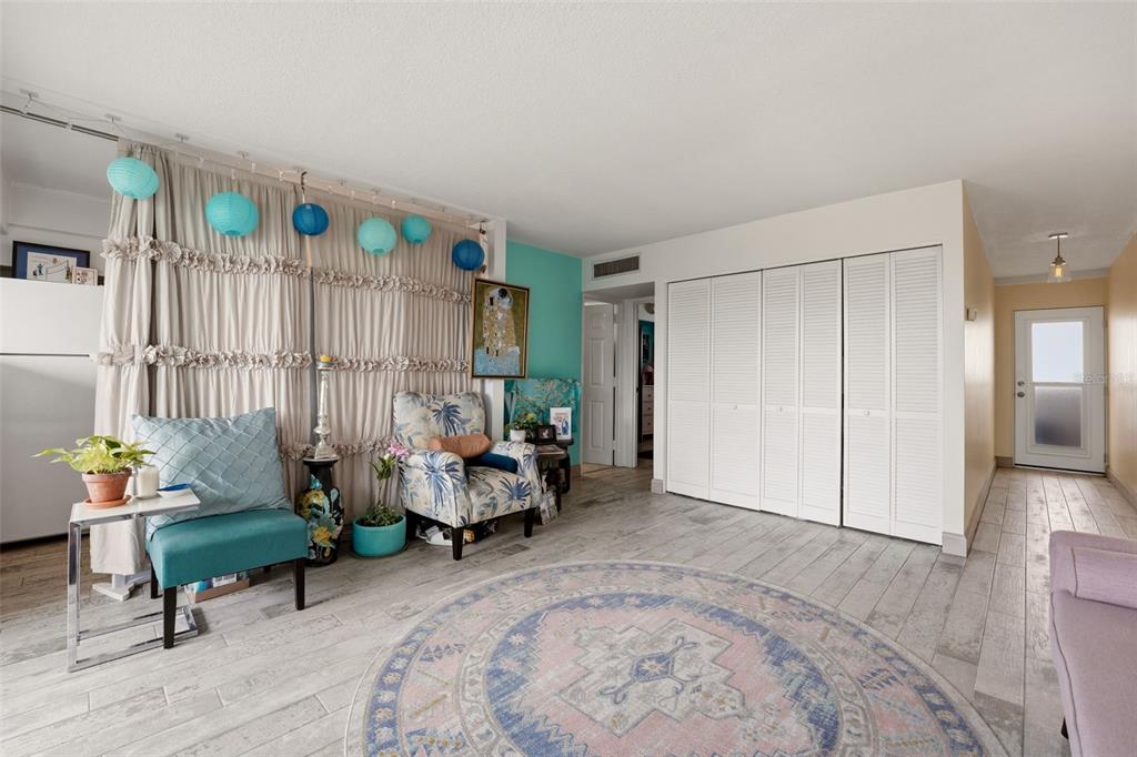 A living room features light wood-look tile floors, a round rug, and white closet doors — 33 S GULFSTREAM AVENUE UNIT 404, SARASOTA, FL