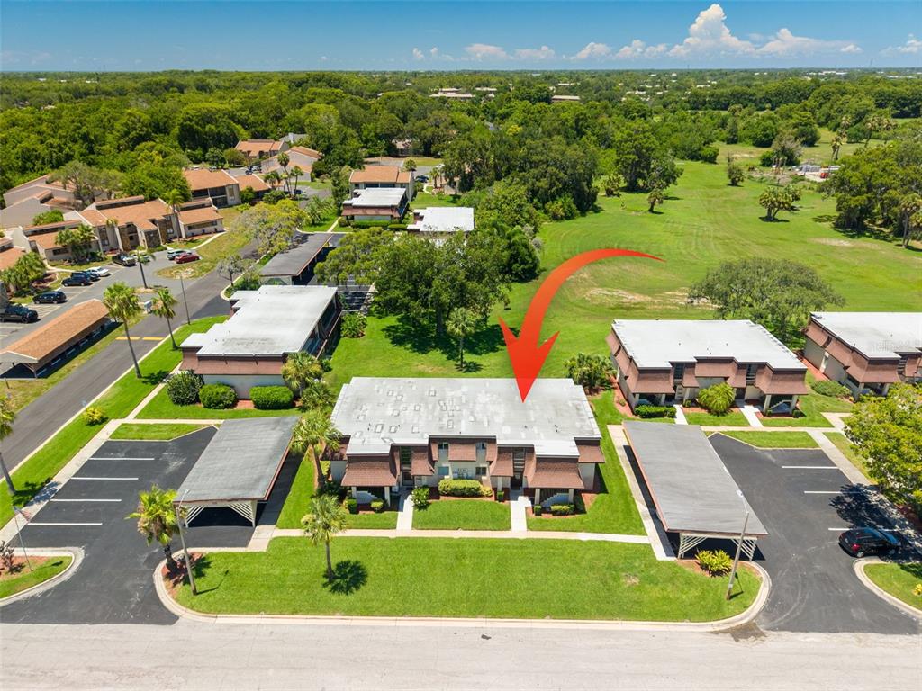 An aerial view shows a two-story apartment building with a flat roof and carports — 7131 DELL ROAD UNIT 2, NEW PORT RICHEY, FL