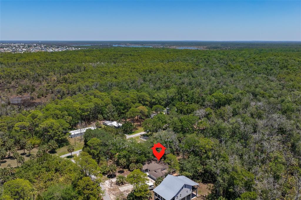 An aerial view shows a house surrounded by dense forest with a red location marker — 1578 INDIAN BAY ROAD, SPRING HILL, FL