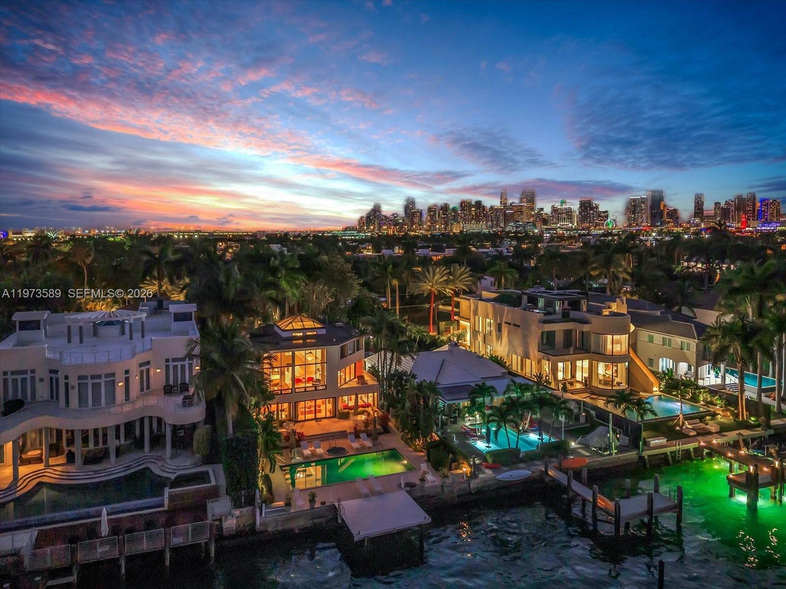 An aerial view of waterfront luxury homes with swimming pools at sunset near a city skyline — 279 N Hibiscus Dr # 0, Miami Beach FL 33139, MIAMI BEACH, FL