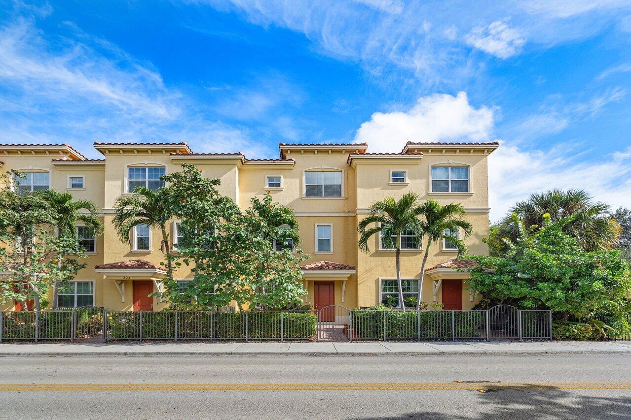 A three-story yellow townhouse complex with red doors and palm trees in front — 224 S Federal Highway # 4, FL 33460, FL