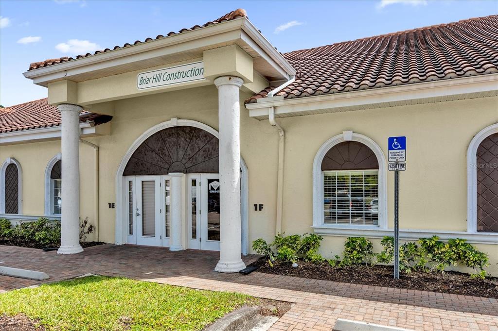 The exterior of a commercial building features a covered entrance with columns and arched windows — 1507 PARK CENTER DRIVE UNIT F, ORLANDO, FL