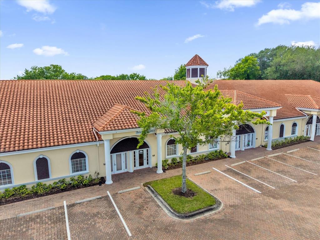 An exterior view of a single-story commercial building with a tiled roof and parking lot — 1507 PARK CENTER DRIVE UNIT F, ORLANDO, FL