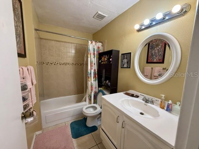 A bathroom features a white vanity, a round mirror, a toilet, and a tiled shower — 3012 PARKWAY BOULEVARD UNIT 106, KISSIMMEE, FL