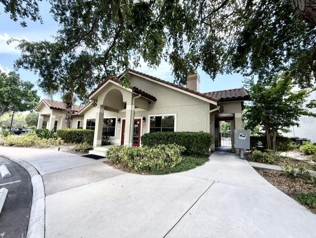 A beige stucco building with a covered entrance and a paved driveway — 3012 PARKWAY BOULEVARD UNIT 106, KISSIMMEE, FL