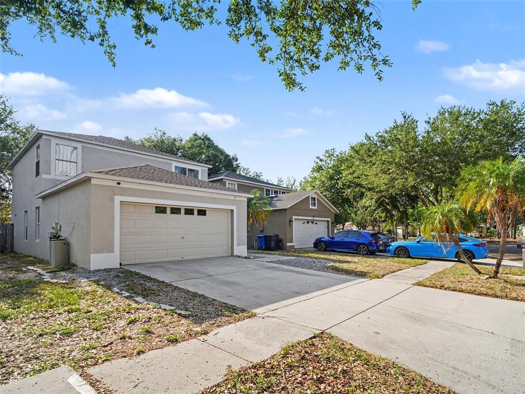 A two-story house with a beige stucco exterior and a two-car garage — 8430 QUARTER HORSE DRIVE, RIVERVIEW, FL