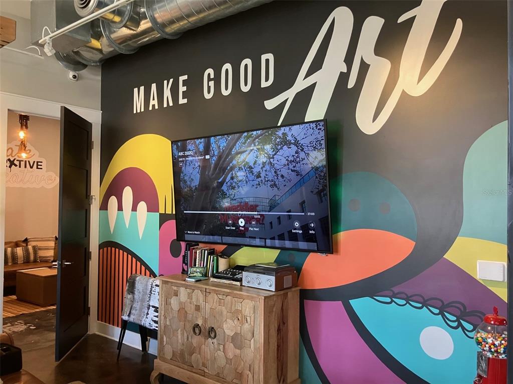 A wall with a colorful mural and the words Make Good Art features a television — 6401 N NEBRASKA AVENUE, TAMPA, FL