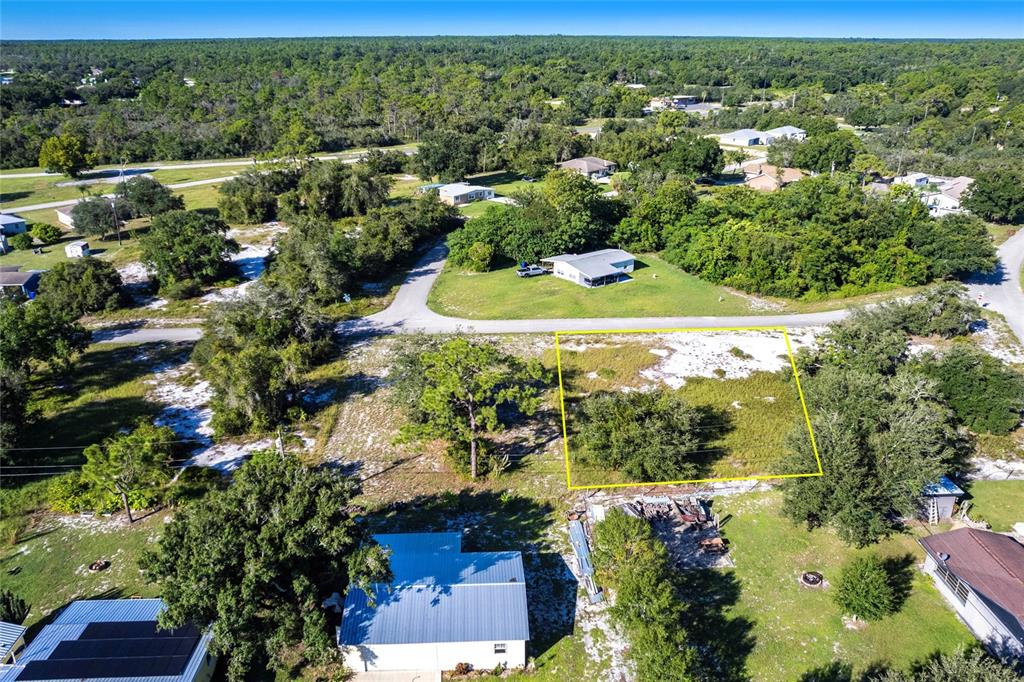 An aerial view shows a vacant, rectangular lot outlined in yellow near a residential street — 917 HOLLYHOCK COURT, LAKE PLACID, FL