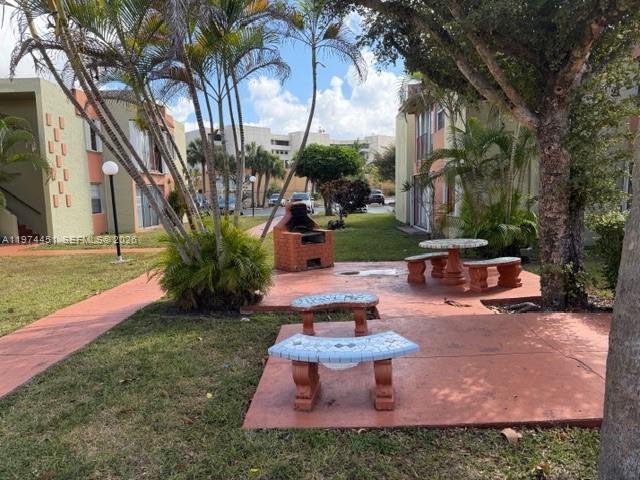 An outdoor common area features a brick grill, a table, and benches on a patio — 9390 W Flagler St # 206C, Miami FL 33174, MIAMI, FL