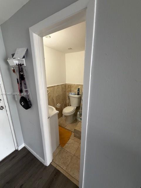 A view through a doorway into a small bathroom with a toilet and tiled walls — 9390 W Flagler St # 206C, Miami FL 33174, MIAMI, FL
