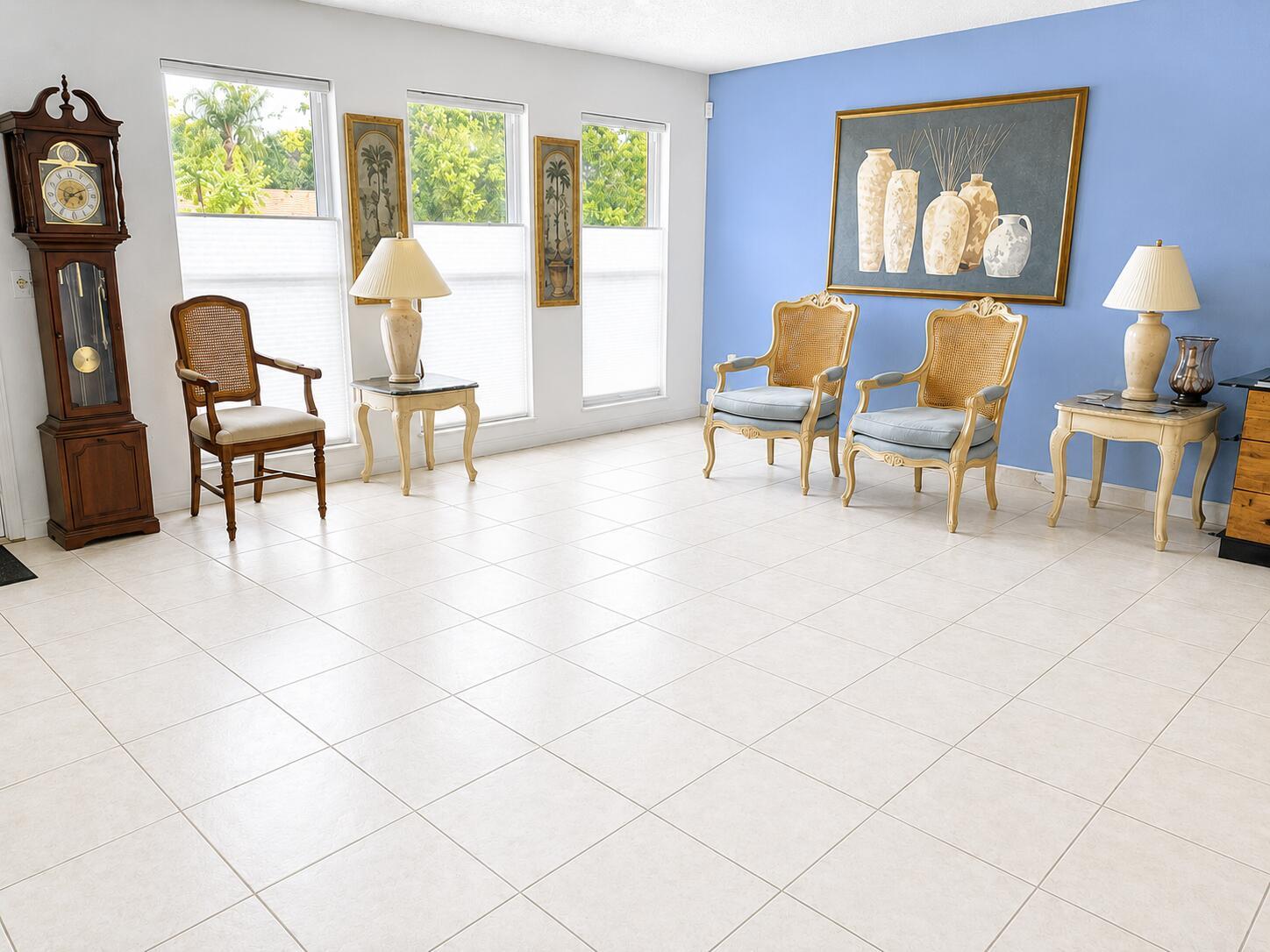 A living room with light tile floors, a blue accent wall, and traditional wooden furniture — 14582 Sunny Waters Lane, Delray Beach FL 33484, DELRAY BEACH, FL