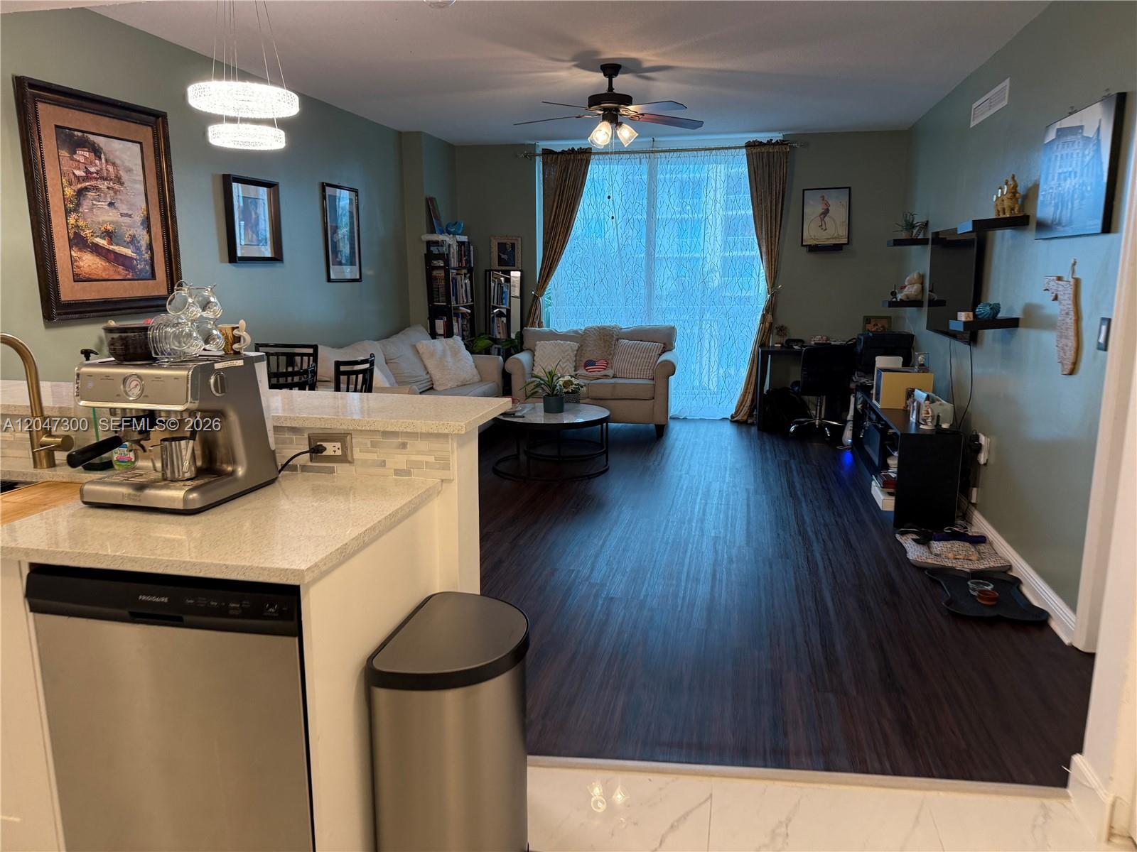 A modern kitchen features white cabinets, stainless steel appliances, and white marble-patterned tile floors — 1745 E Hallandale Beach Blvd # 304W, Hallandale Beach FL 33009, HALLANDALE BEACH, FL