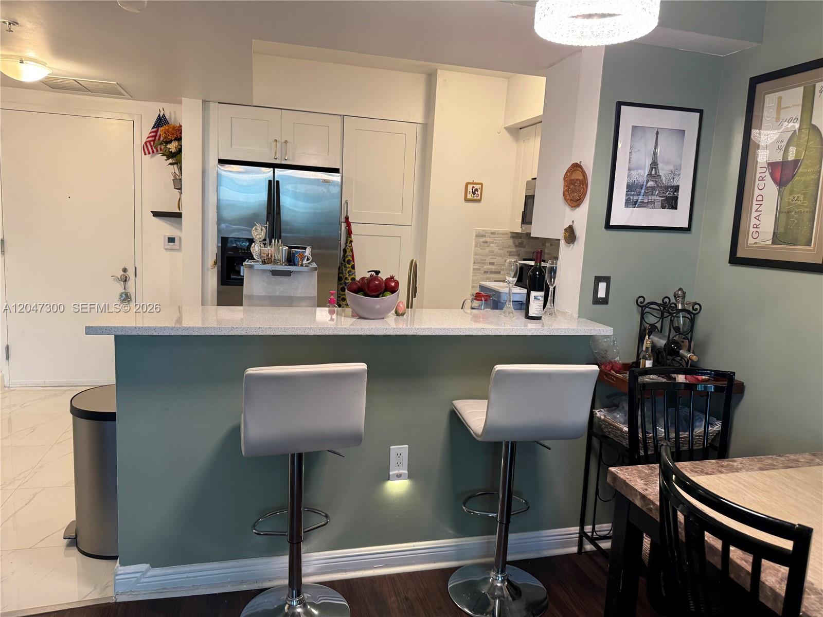 A kitchen sink area features a gold faucet, a wooden cutting board, and a coffee machine — 1745 E Hallandale Beach Blvd # 304W, Hallandale Beach FL 33009, HALLANDALE BEACH, FL