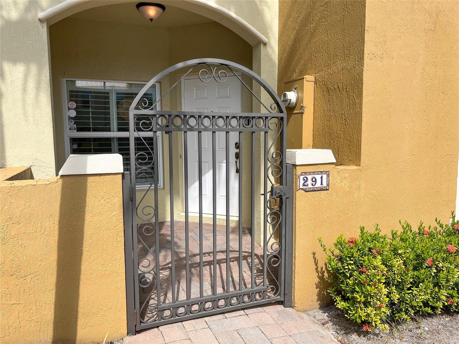 A metal gate stands in front of a white front door with a house number 291 — 291 Lake Monterey Circle, Boynton Beach FL 33426, BOYNTON BEACH, FL