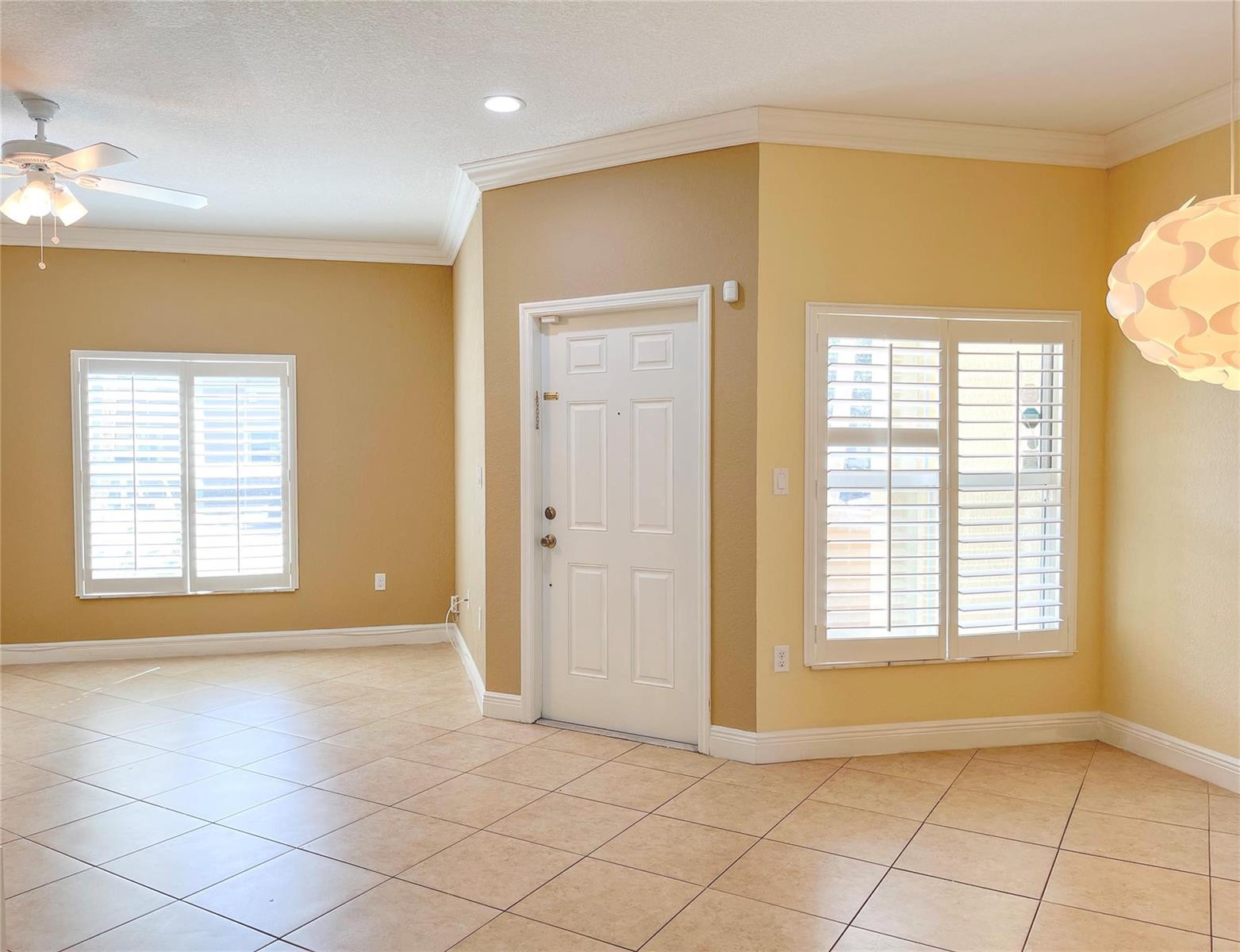 An interior view of a room with tile floors, a white door, and plantation shutters — 291 Lake Monterey Circle, Boynton Beach FL 33426, BOYNTON BEACH, FL