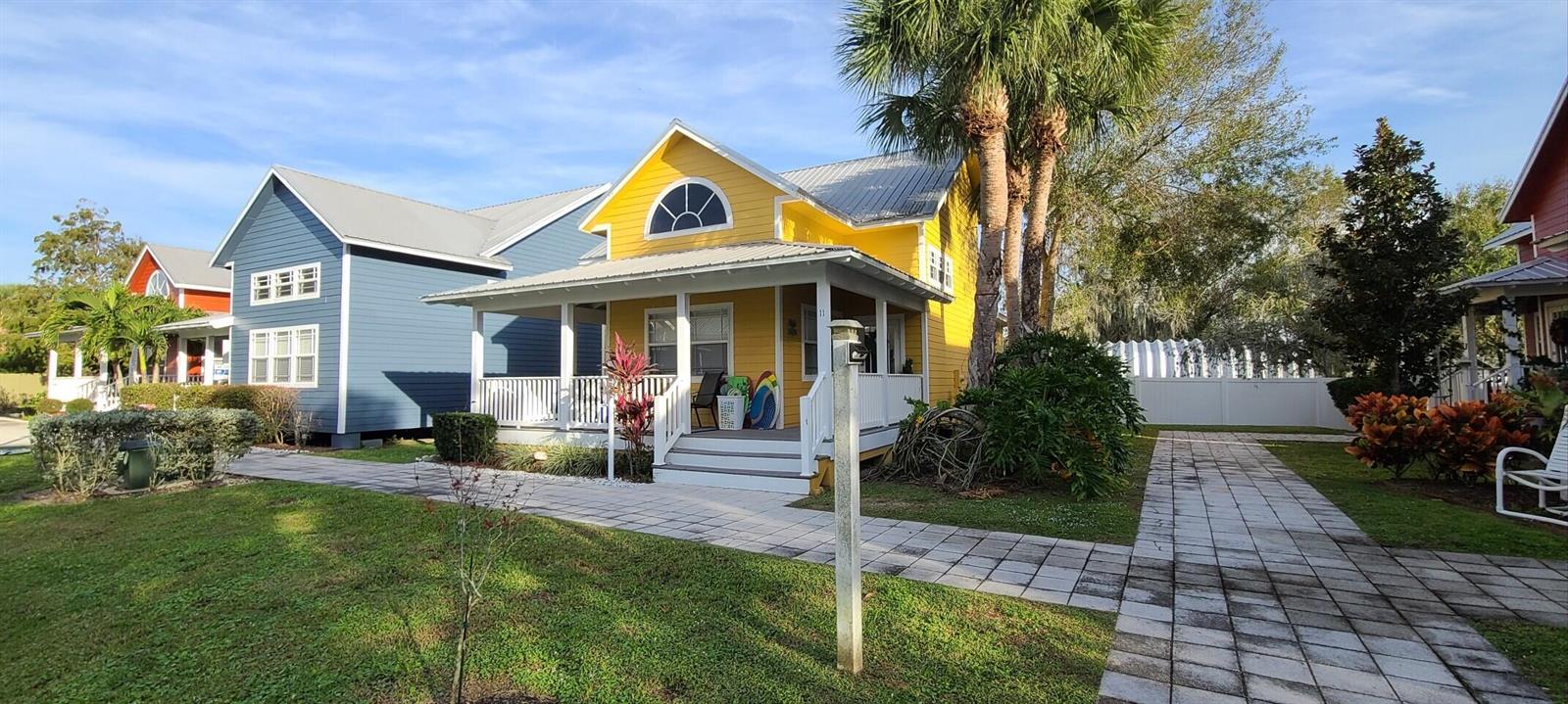 A yellow house with a front porch and metal roof sits next to a blue house — 4334 SE Us Highway 441 # 11, Okeechobee FL 34974, OKEECHOBEE, FL