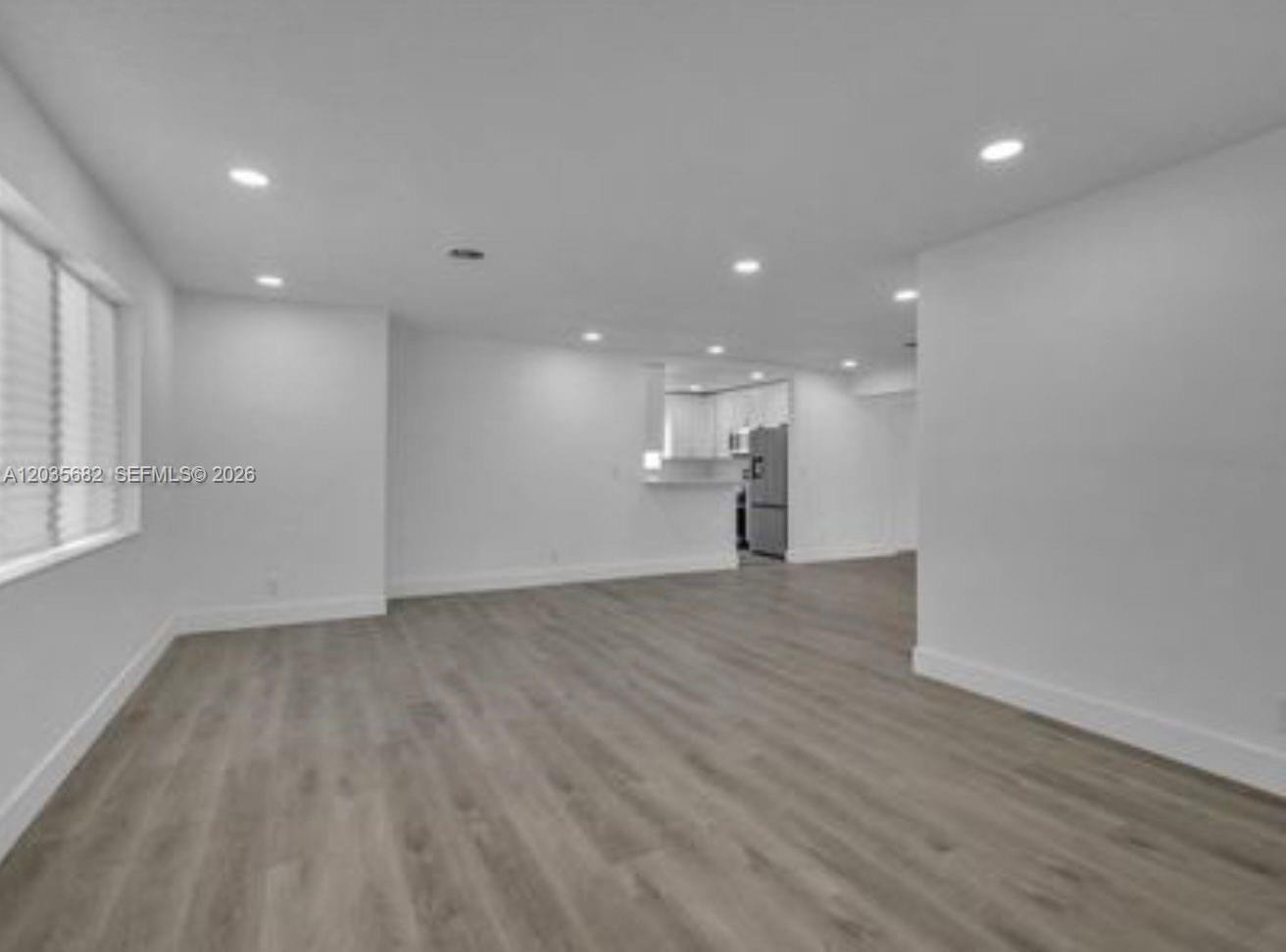 An open-concept living area features light wood-look flooring, white walls, and recessed ceiling lighting — 3811 NW 6th Pl # 0, Lauderhill FL 33311, LAUDERHILL, FL