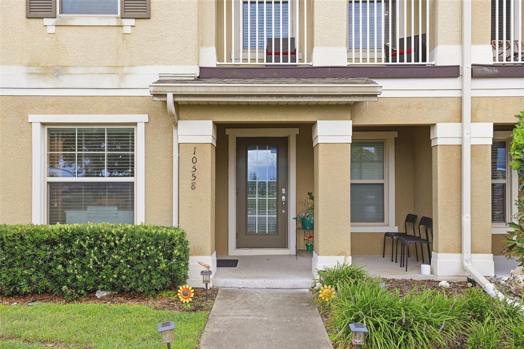 The exterior of a two-story home features a covered entryway, a front door, and windows — 10558 GREEN IVY LANE, ORLANDO, FL