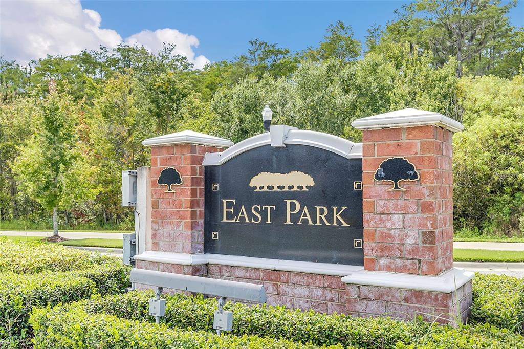 A brick monument sign with the words East Park stands in front of lush trees — 10558 GREEN IVY LANE, ORLANDO, FL