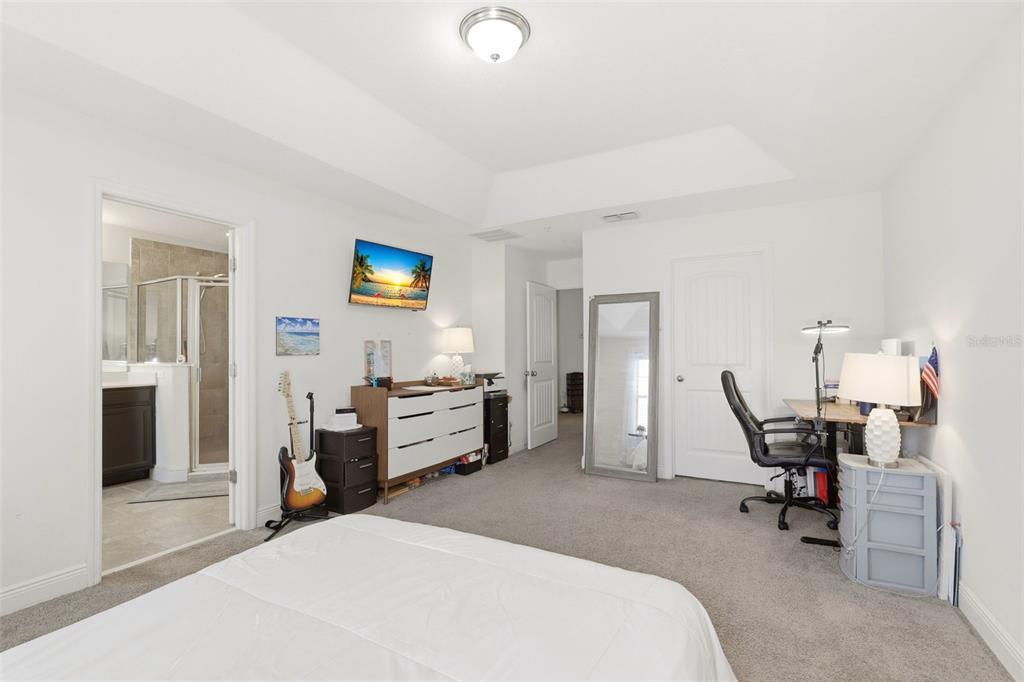 A bedroom features a white bed, a desk, a dresser, and an attached bathroom — 10558 GREEN IVY LANE, ORLANDO, FL