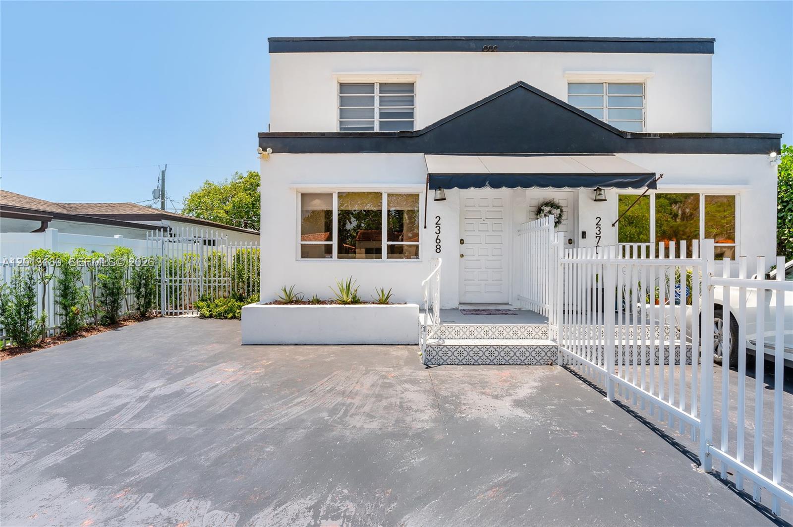 A two-story white building with a black awning and a paved driveway in front — 2368 SW 26th St # A, Miami FL 33133, MIAMI, FL