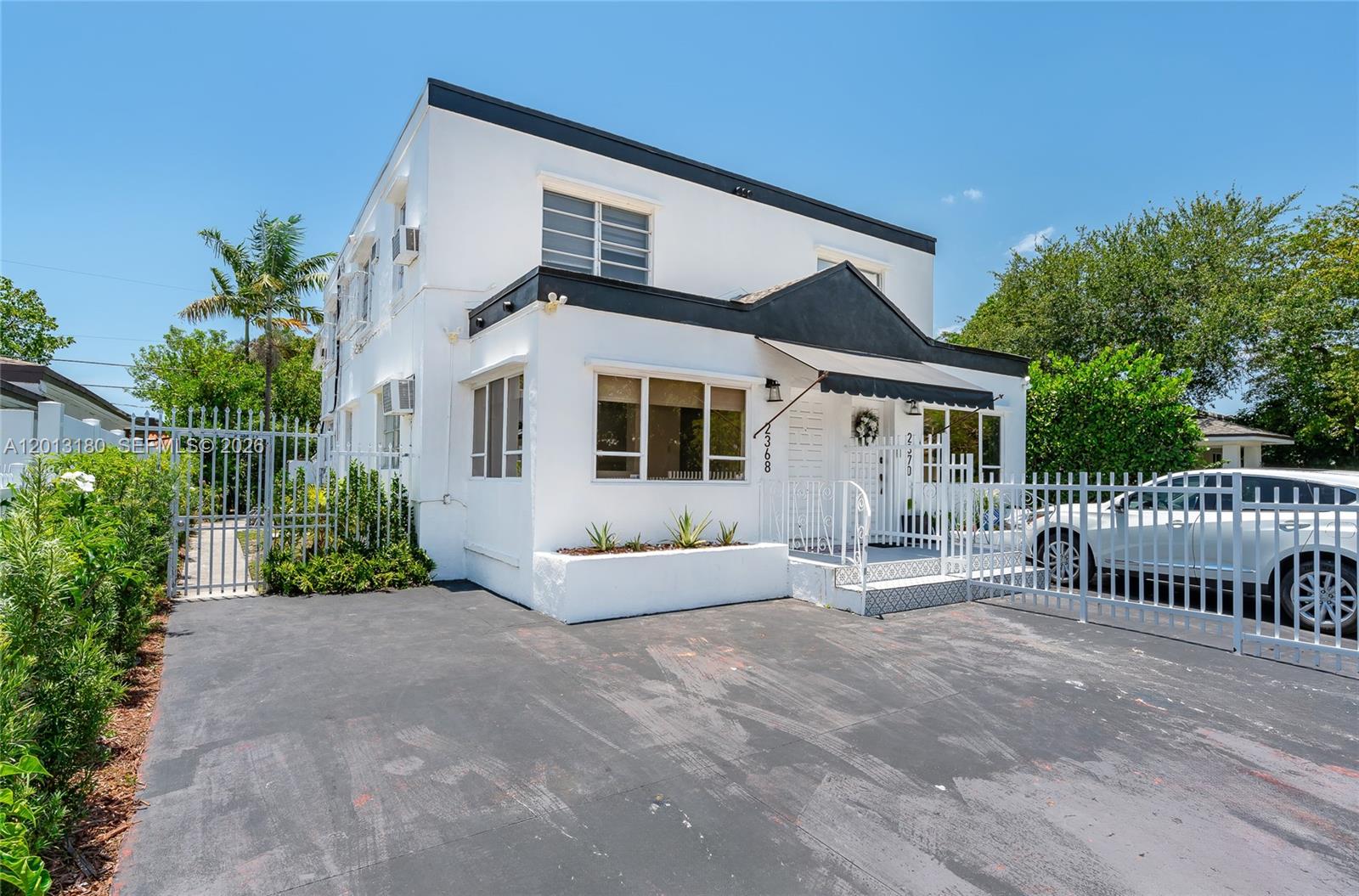 A two-story white building with a black trim and a paved driveway behind a fence — 2368 SW 26th St # A, Miami FL 33133, MIAMI, FL