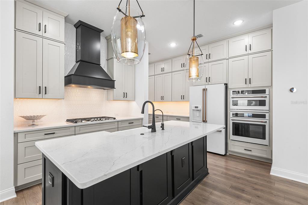 A modern kitchen features light gray cabinets, a black island, white countertops, and stainless appliances — 1619 S OSCEOLA AVENUE, ORLANDO, FL