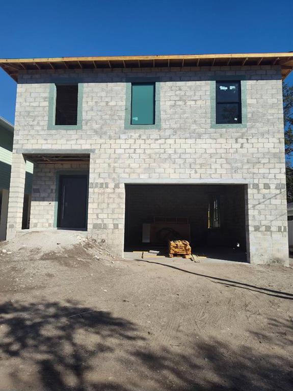 A two-story concrete block house under construction with an installed front door and garage opening — 6010 S ELKINS AVENUE, TAMPA, FL