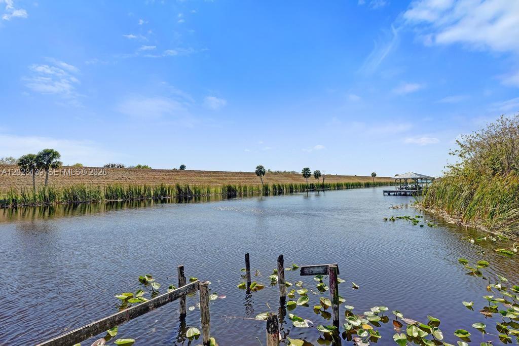 A view of a canal with a wooden dock and a gazebo in the distance — 1421 NE US Highway 441 # 10, Okeechobee FL 34974, OKEECHOBEE, FL