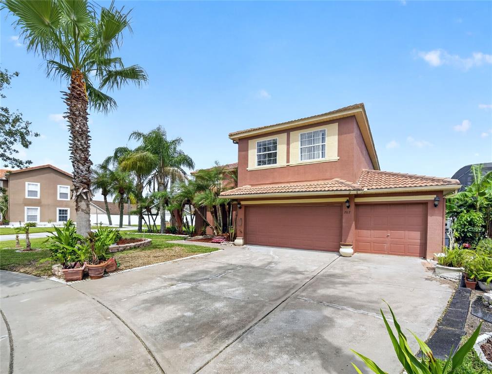 A two-story stucco house with a three-car garage and palm trees in the front yard — 202 WOODSON COURT, KISSIMMEE, FL