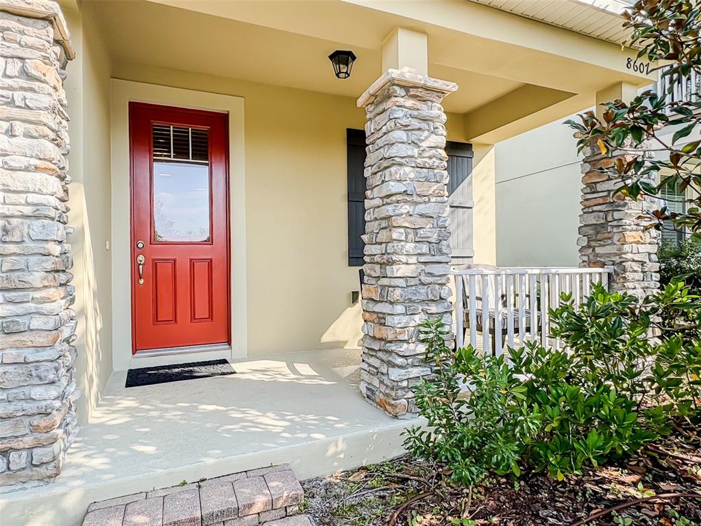 A front porch features a red door, stone columns, and a white railing — 8607 RANDAL PARK BOULEVARD, ORLANDO, FL