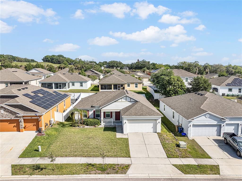 An aerial view shows a suburban neighborhood with single-family homes and a paved street — 1328 WATER WILLOW DRIVE, GROVELAND, FL