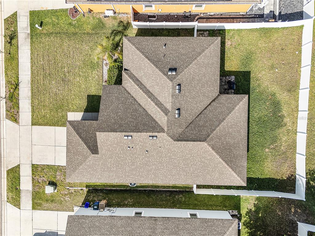 An aerial view shows the roof of a house surrounded by a fenced yard — 1328 WATER WILLOW DRIVE, GROVELAND, FL