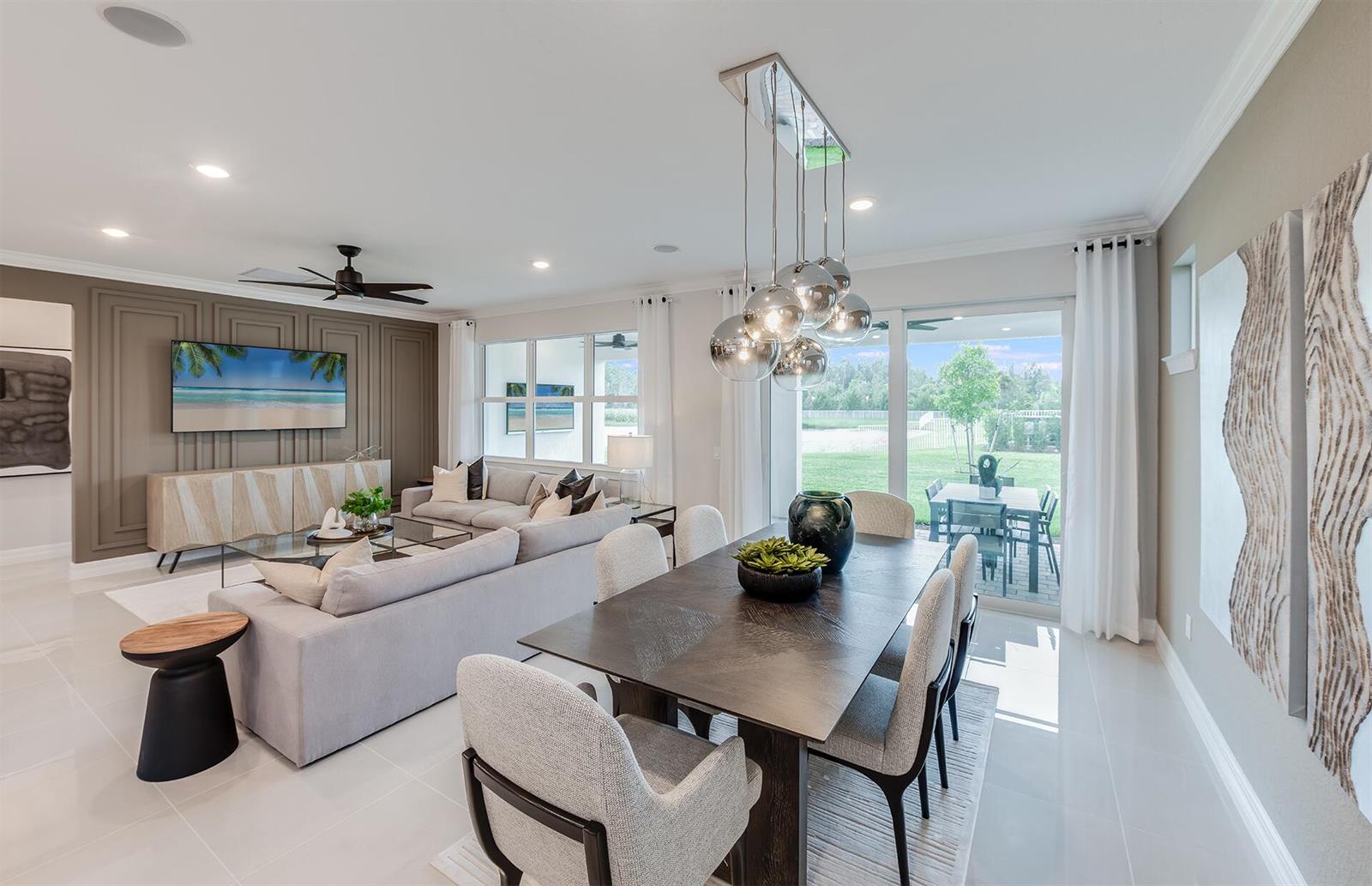 A modern open-concept living and dining area features a dark wood table and paneled wall — 1205 Haven Circle # 30, Vero Beach FL 32960, VERO BEACH, FL