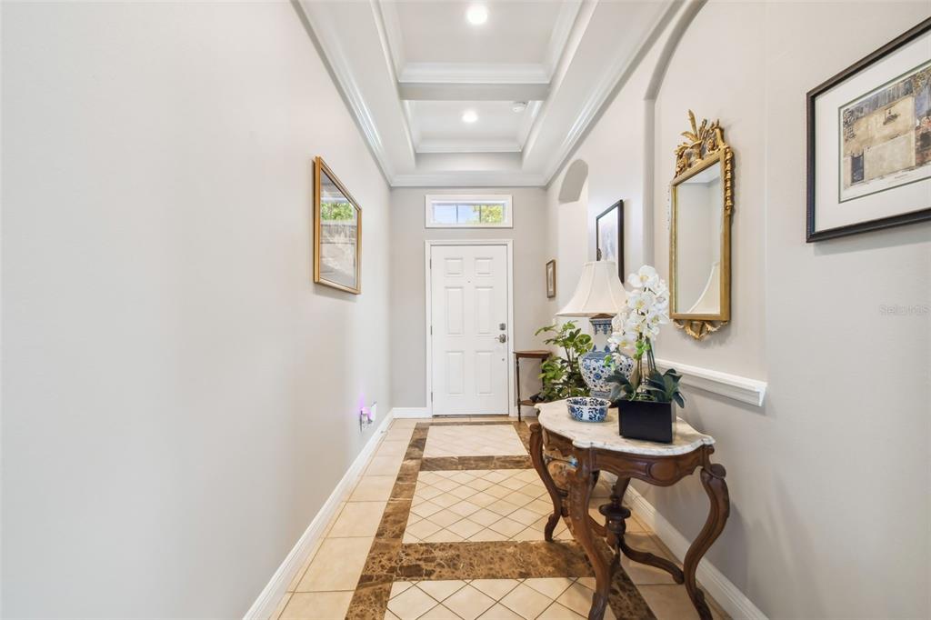A foyer features a tray ceiling, tiled floor with decorative borders, and a console table — 5056 LAKEHURST COURT, PALMETTO, FL