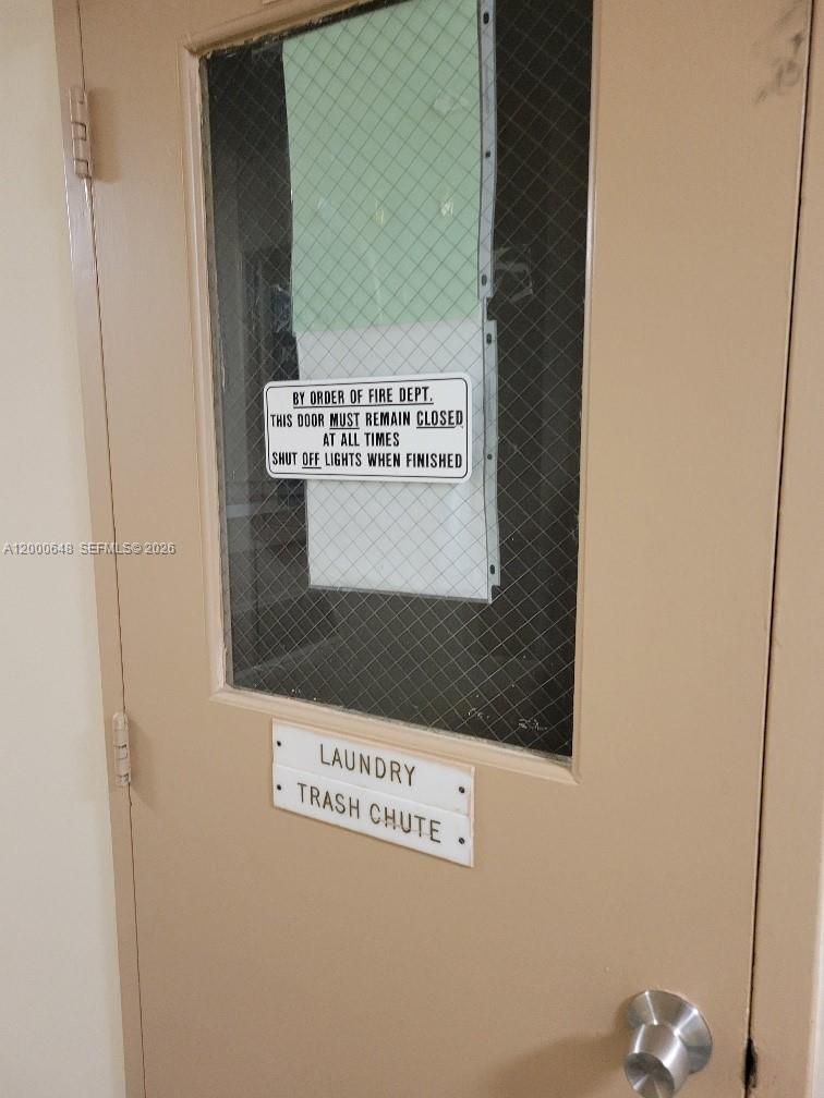 A beige door with a wire-reinforced glass window features signs for a laundry and trash chute — 1833 S Ocean Dr # 307, Hallandale Beach FL 33009, HALLANDALE BEACH, FL