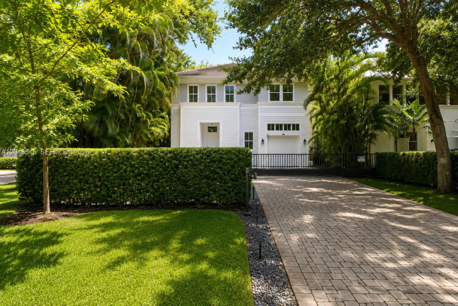 A two-story white house with a paved driveway and a tall hedge in the front — 4724 SW 72nd ST, Miami FL 33143, MIAMI, FL