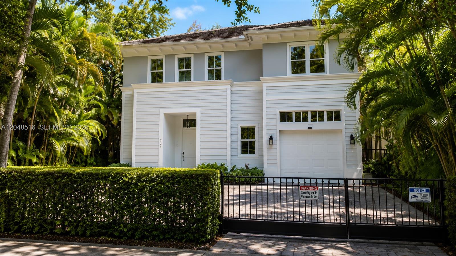 A two-story house with white siding, a garage, and a gated driveway behind a hedge — 4724 SW 72nd ST, Miami FL 33143, MIAMI, FL