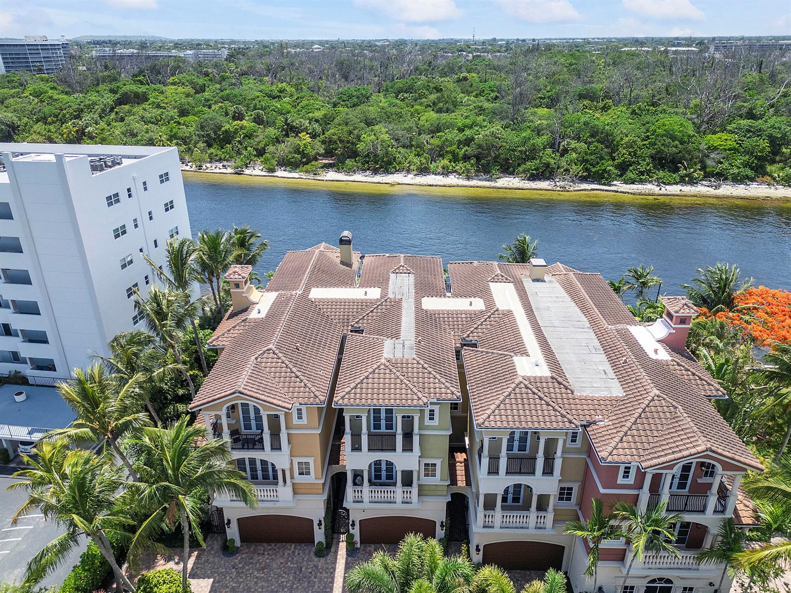 A waterfront view features a wooden dock with two boats and palm trees under a sky — 449 NE 19th Avenue, Deerfield Beach FL 33441, DEERFIELD BEACH, FL