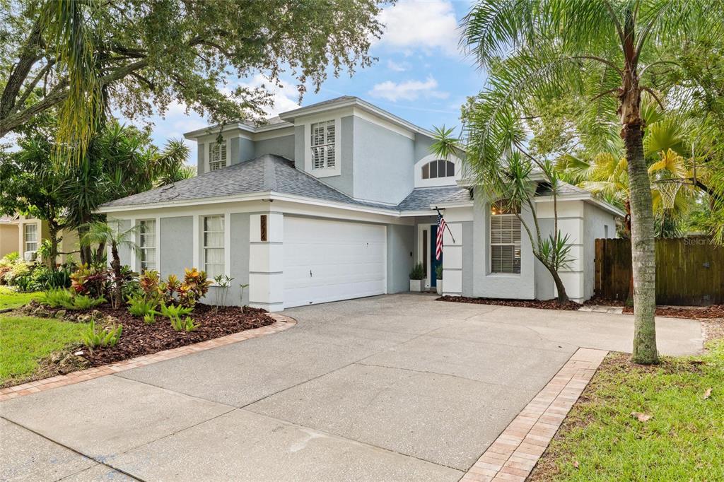A two-story house with a gray stucco exterior, a two-car garage, and a concrete driveway — 3274 MONTROSE CIRCLE, PALM HARBOR, FL