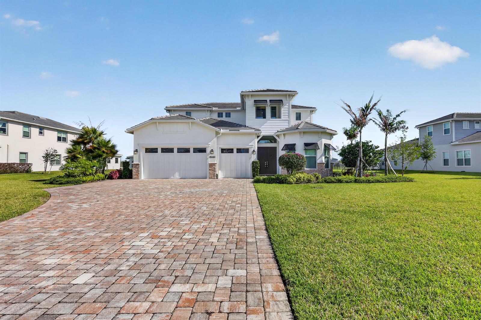 A two-story white house with a paved driveway and a large front lawn — 20160 SE Bridgewater Drive, Jupiter FL 33458, JUPITER, FL