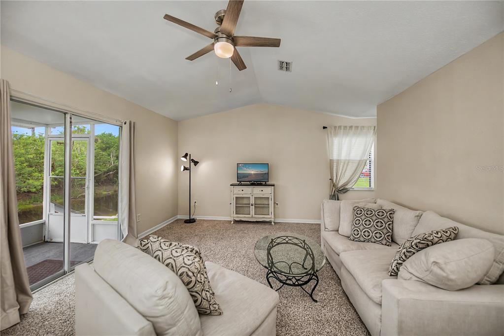 A single-story house with beige vinyl siding, white shutters, and a concrete walkway — 14415 WORTHWHILE ROAD, PORT CHARLOTTE, FL