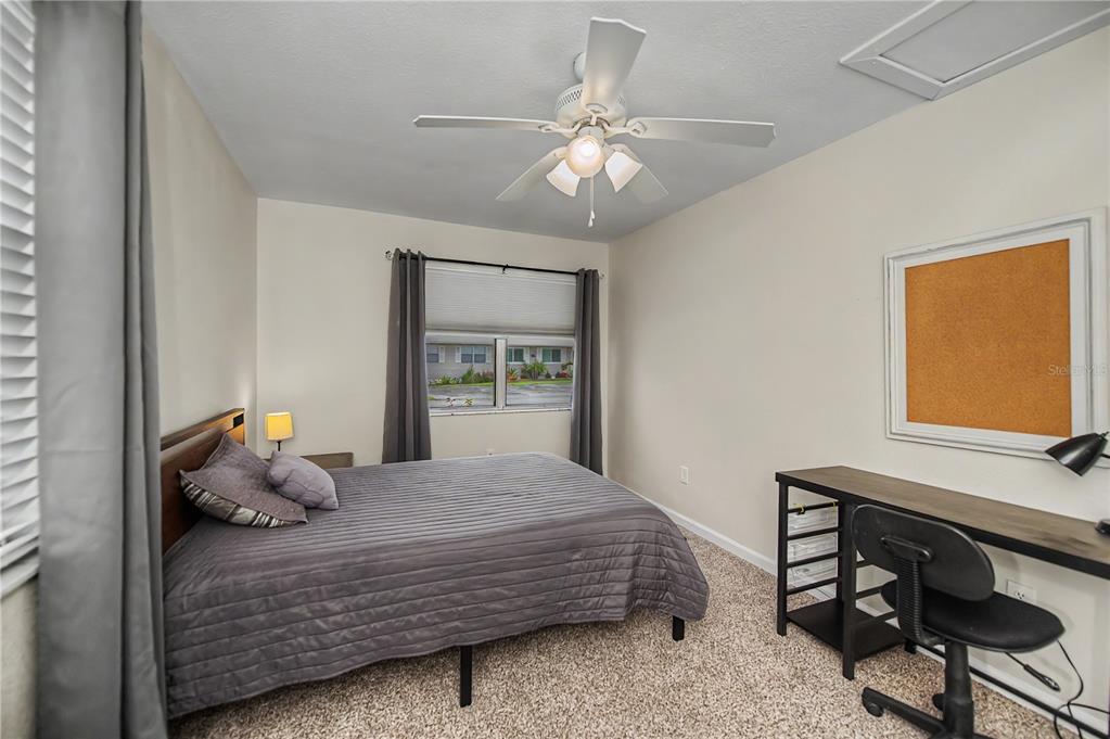 An open-concept kitchen with granite countertops and white cabinets overlooks a carpeted living area — 14415 WORTHWHILE ROAD, PORT CHARLOTTE, FL