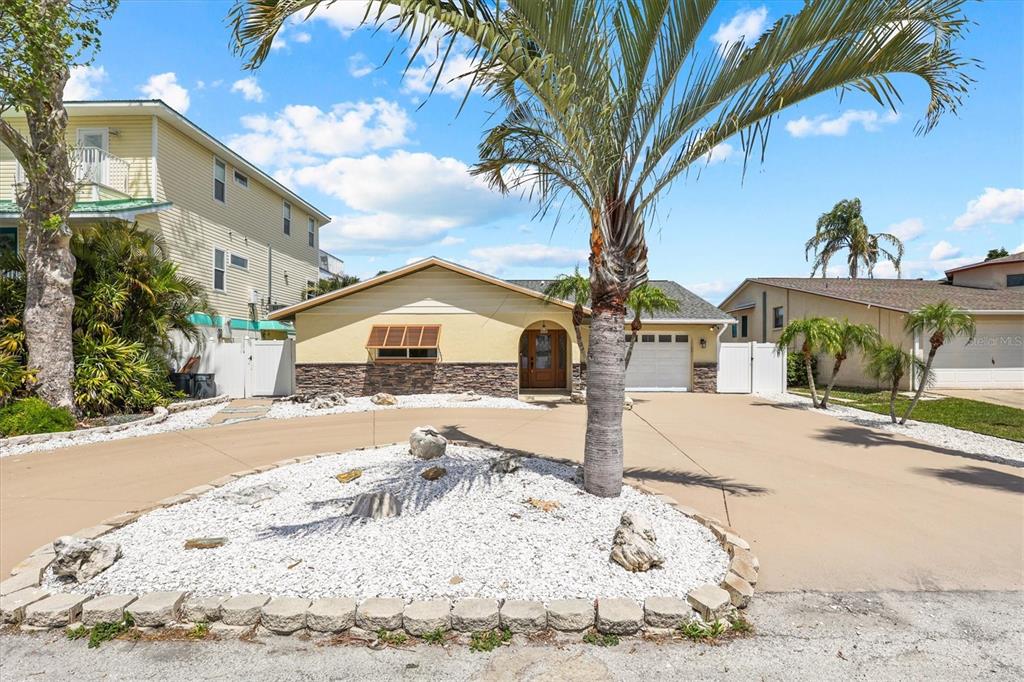 A single-story house with a tan exterior, stone accents, and a circular driveway — 7239 SOUTHWIND DRIVE, HUDSON, FL