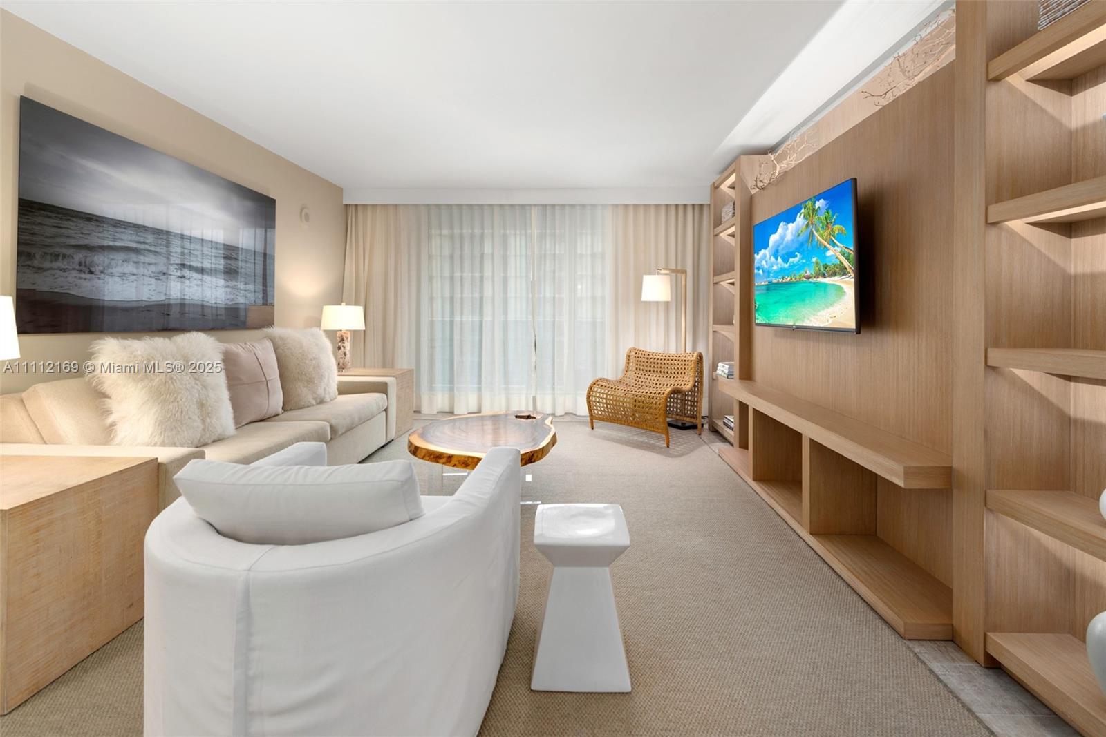 A living room features a light wood media wall, a sofa, and a white armchair — 102 24th St # 1211, Miami Beach FL 33139, MIAMI BEACH, FL